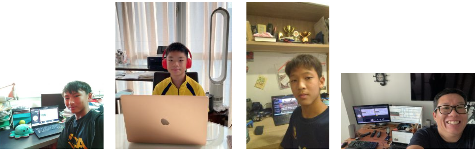 Four people sitting at desks with computers, including three boys and one adult man wearing glasses.